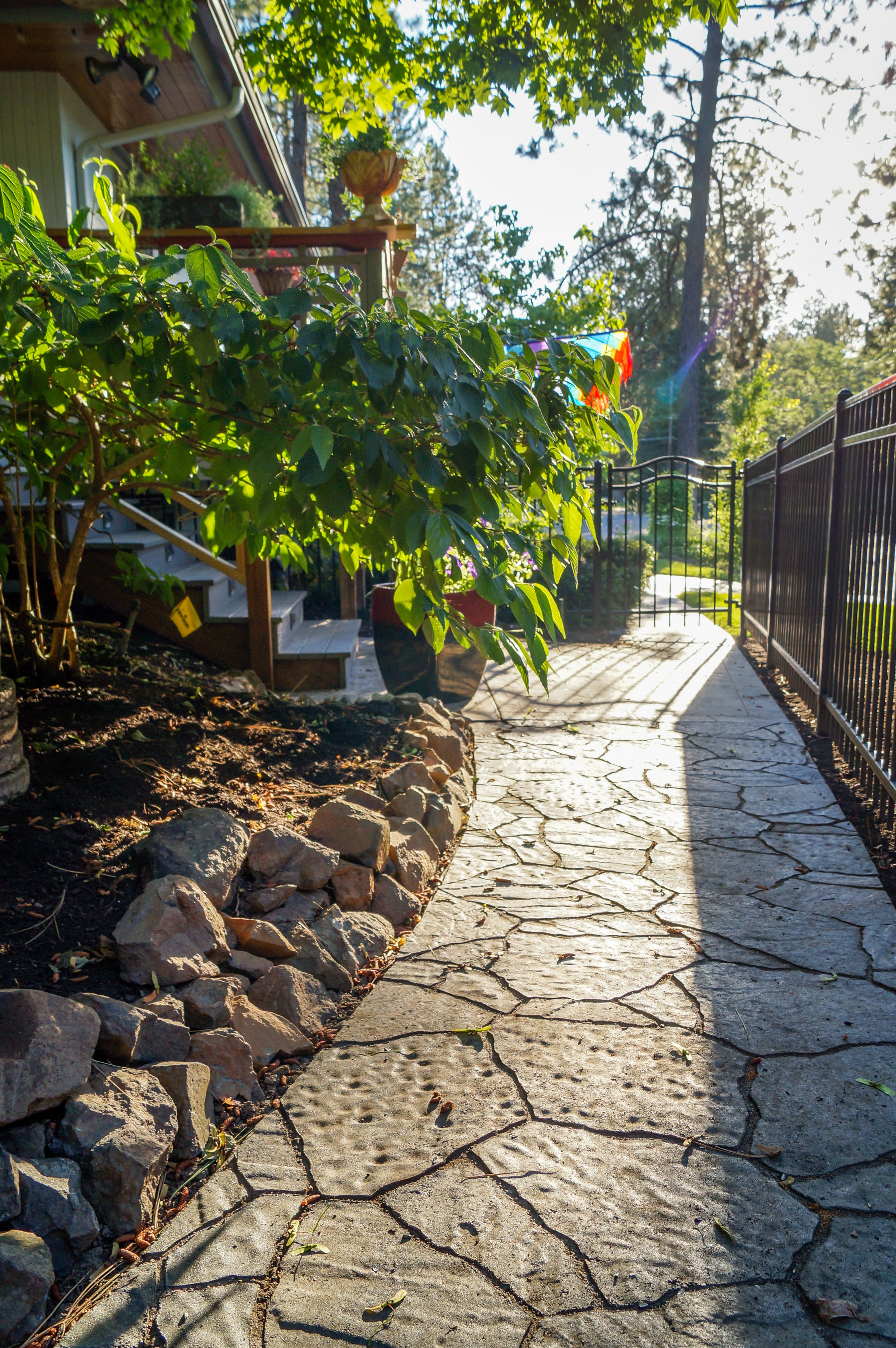 spokane landscape with paver pathway to deck steps on mid century ranch house