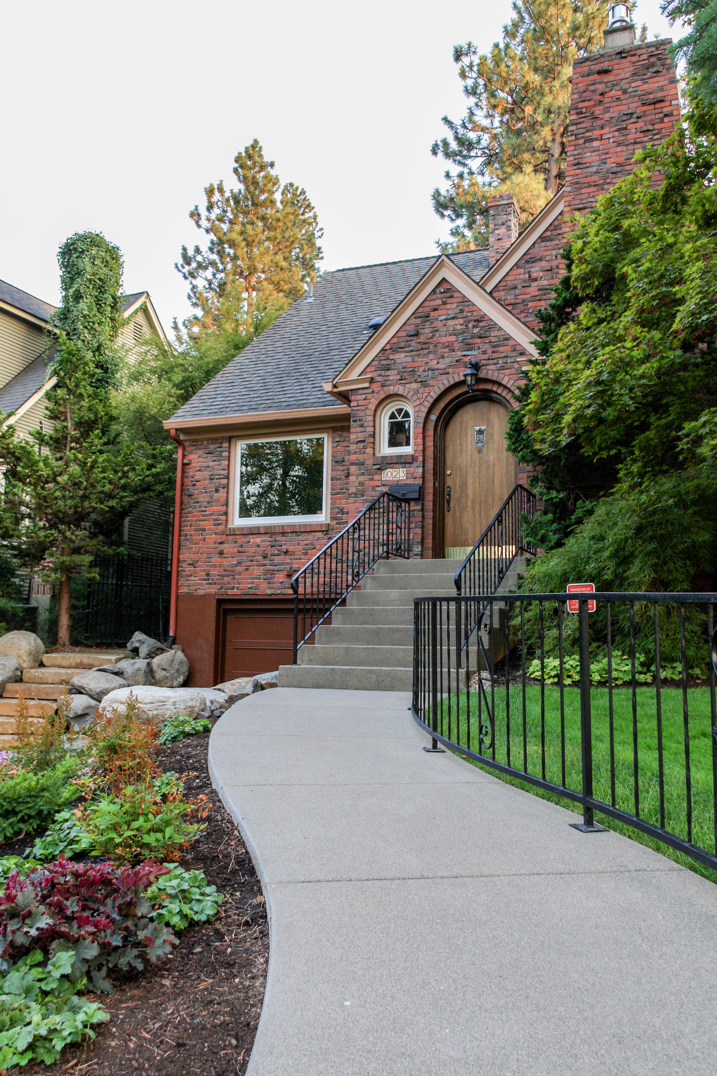 sandwashed concrete sidewalk and brick tudor bungalow