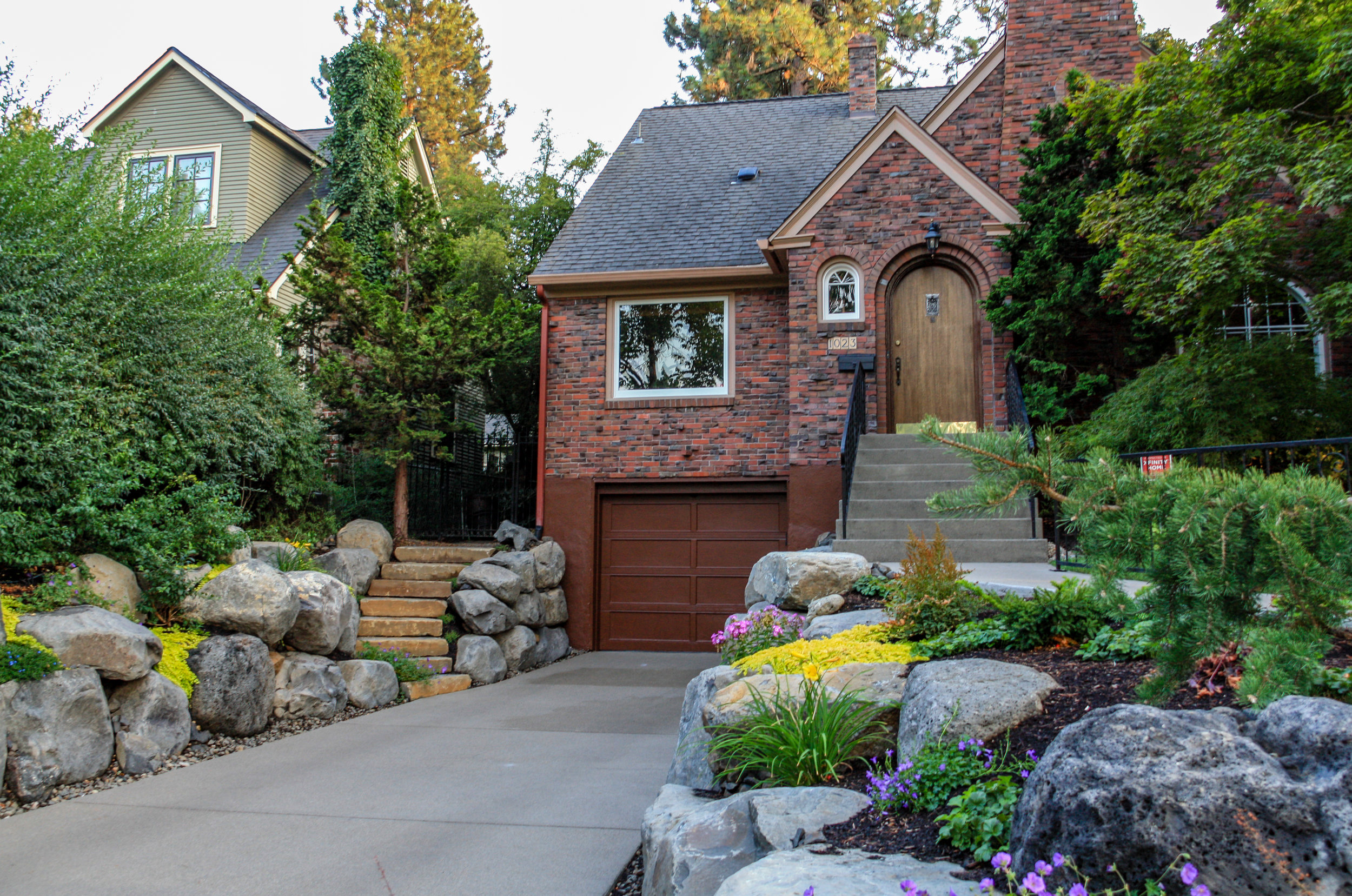 boulder retaining walls around 1930s bungalow driveway