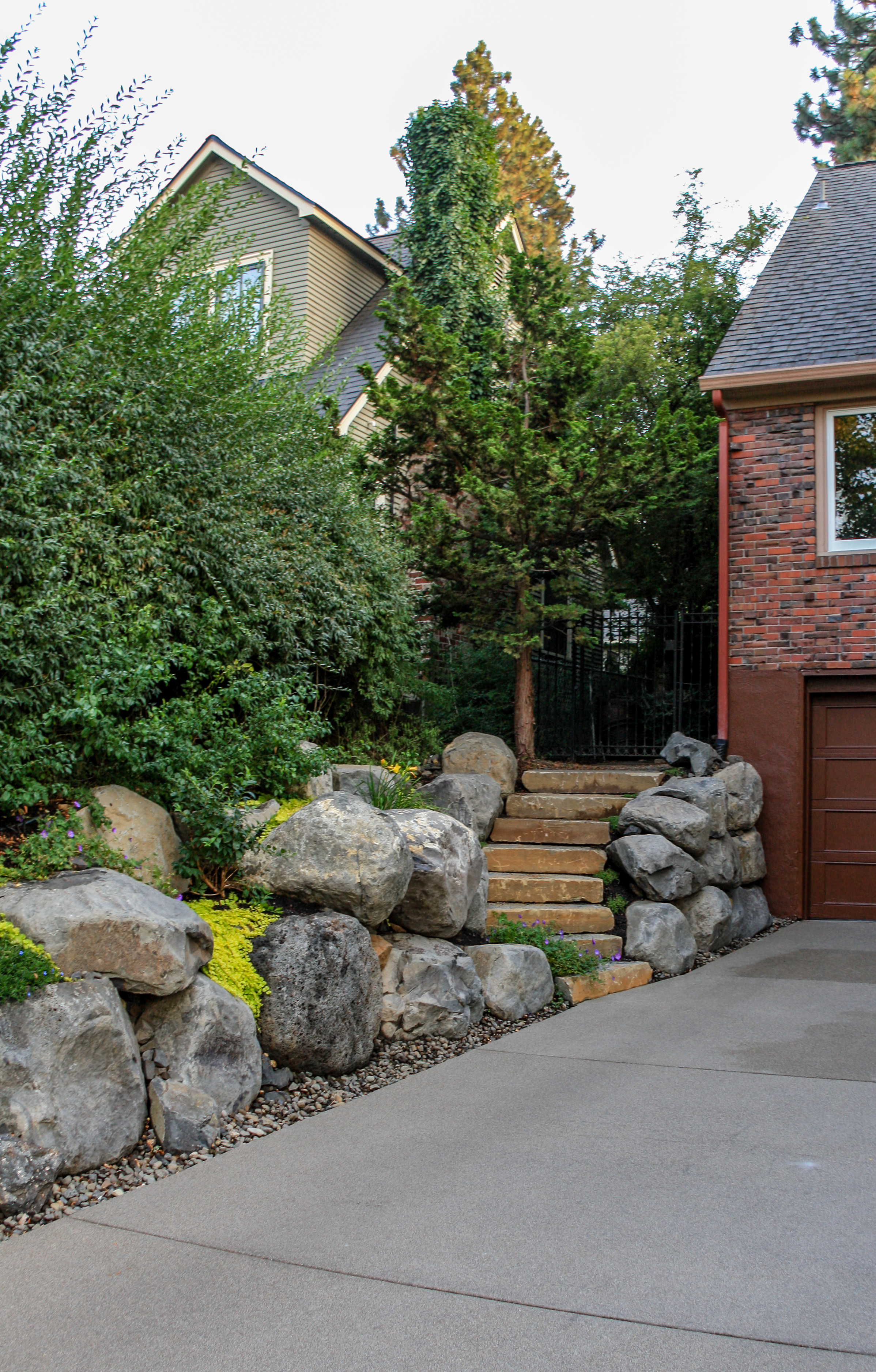 spokane landscaping with boulder retaining walls and sandwashed driveway