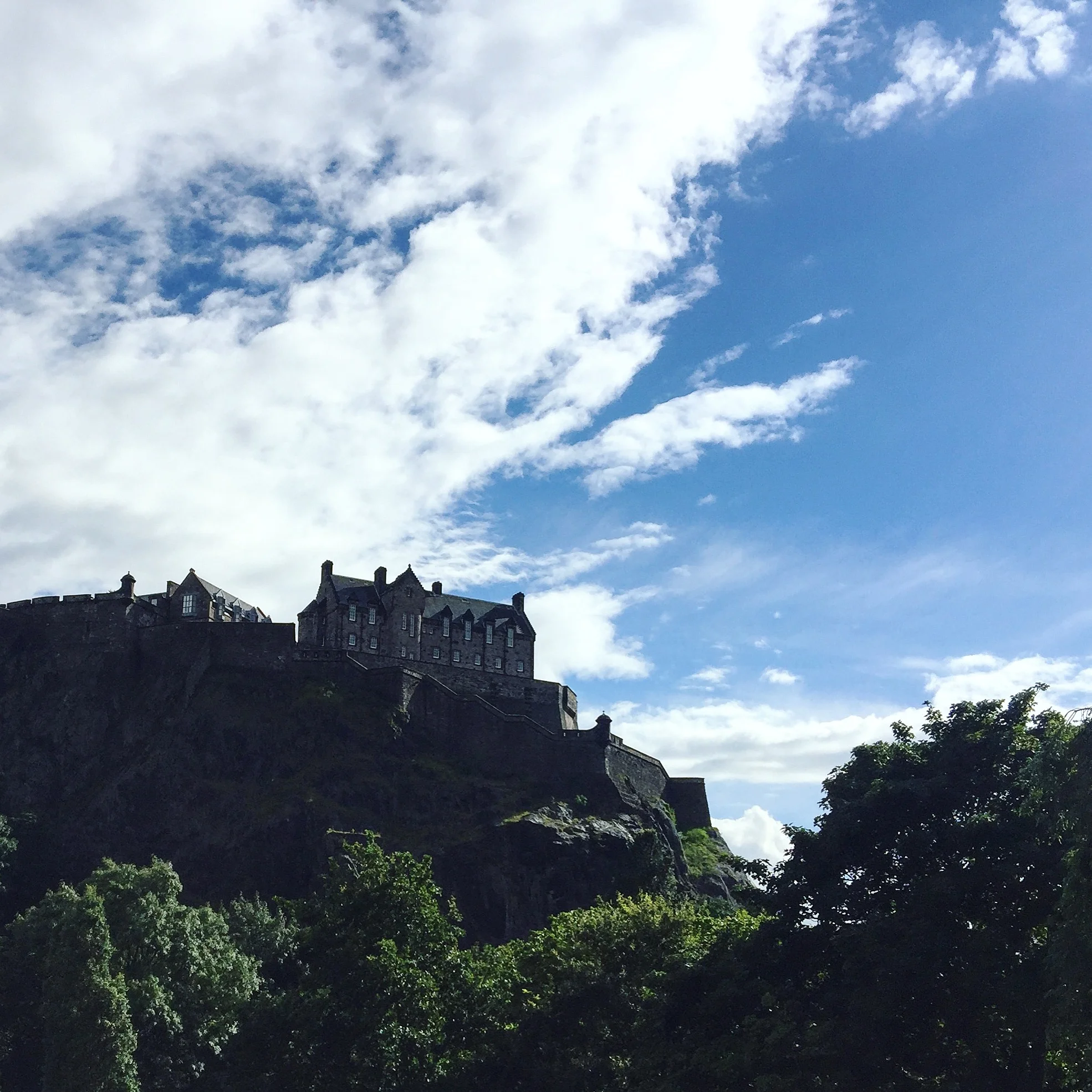 Edinburgh Castle perched dramatically over the city, overlooking Princes Street Gardens.
