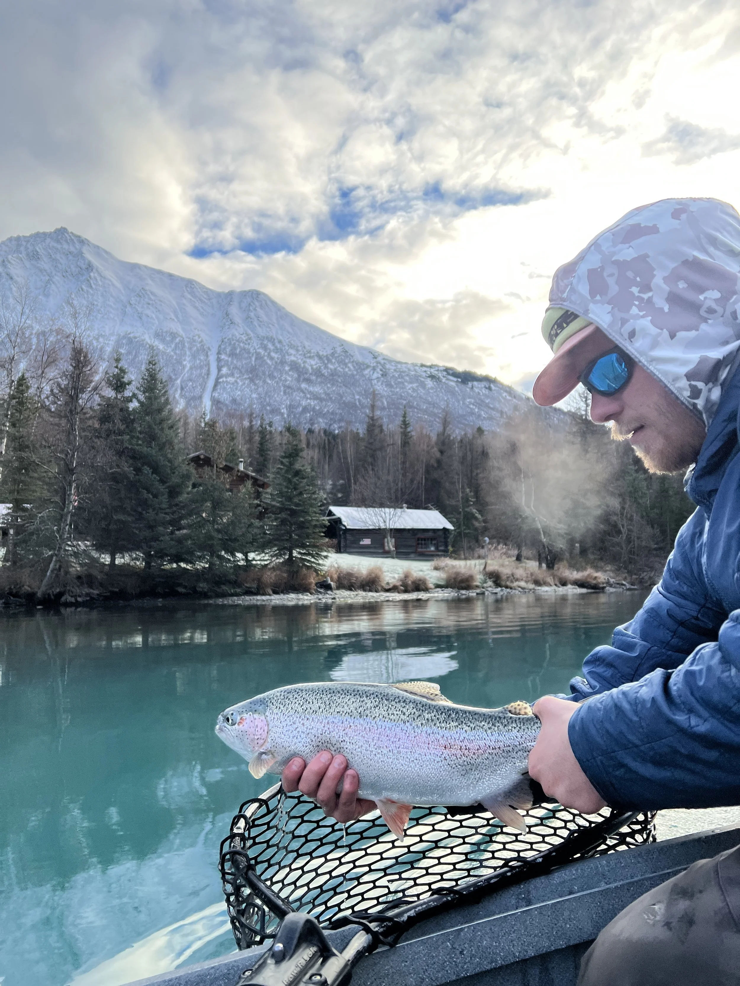 fly fishing guide holding a rainbow trout