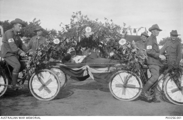 c 1917; an unidentified wounded soldier in a makeshift ambulance formed by four bicycles