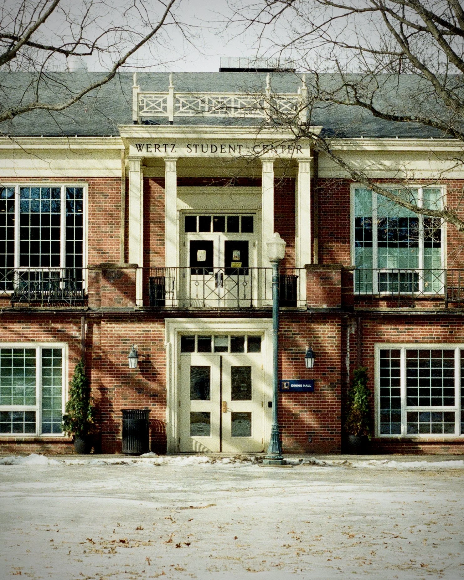 Campus building: Wertz Student Center. Shadows of trees cast on the building. Icy quad in foreground.