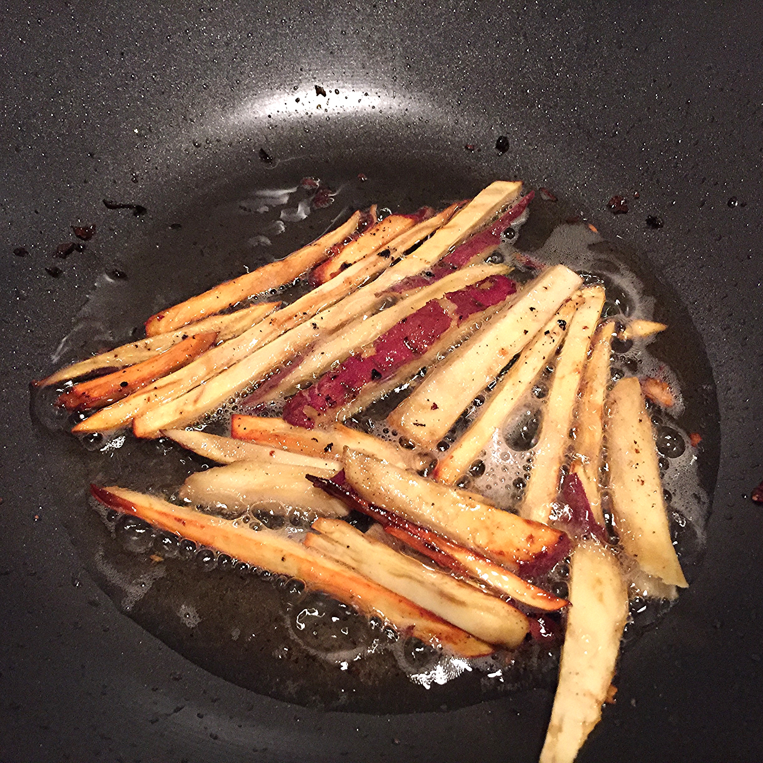 Fried Japanese sweet potatoes in a wok