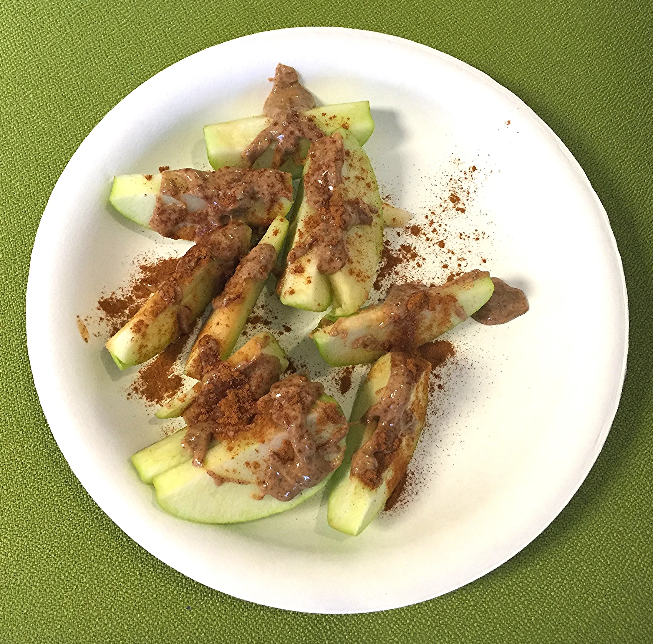 Green apple and almond butter sprinkled with cinnamon