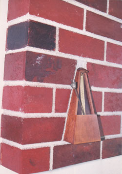 TIME IN STONE Fiber board, brick wall, and a found Seth Thomas metronome.