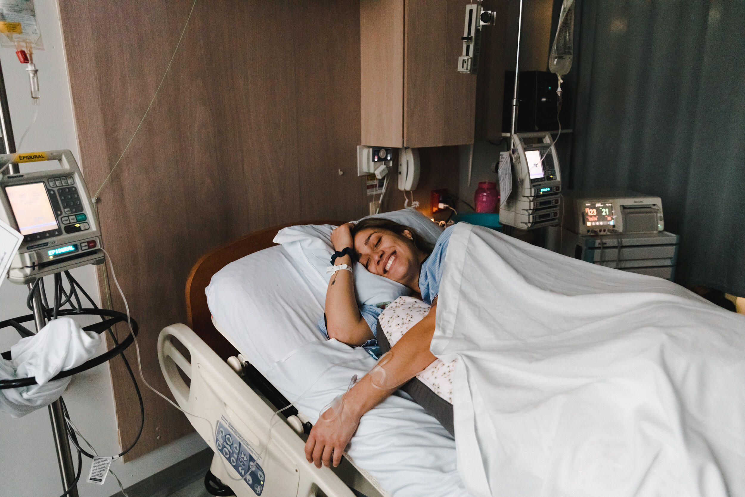 Photo de femme enceinte souriante dans un lit d'hôpital