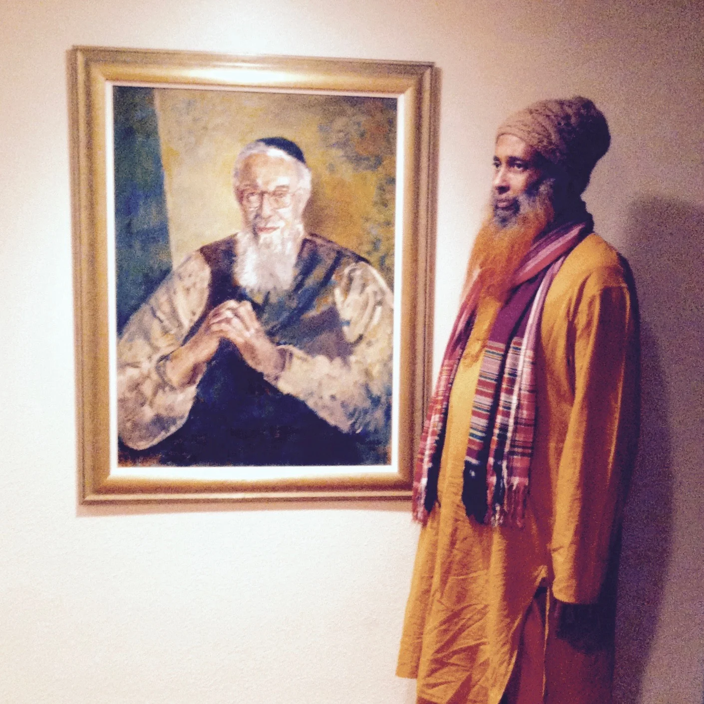 Ibrahim Baba next to a portrait of Reb Zalman in Rabbi Zalman Schachter-Shalomi's library. — Netanel Miles-Yépez, 2015.