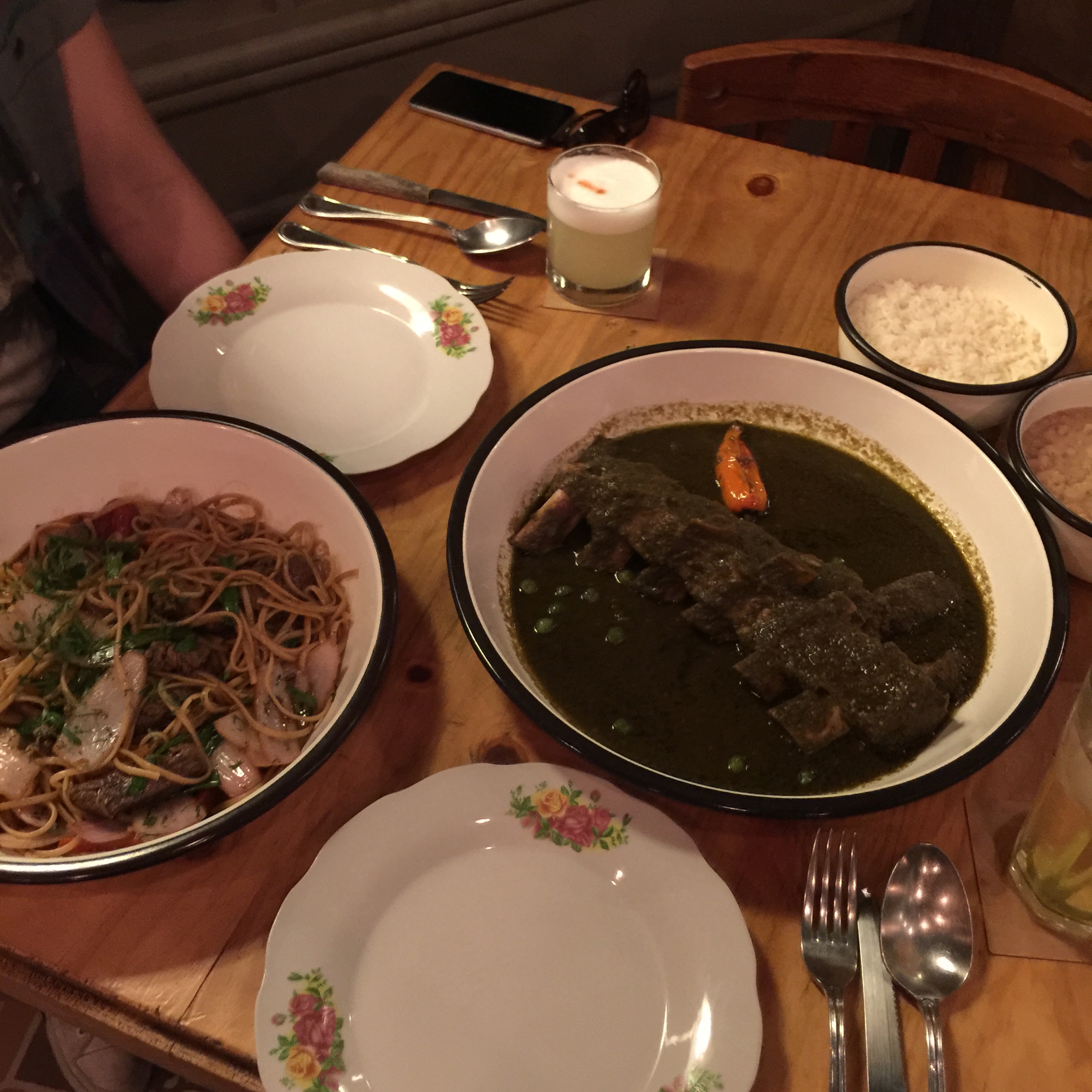Chifa steak and noodles dish (left) and braised short rib in a cilantro based stew (right) at Isolina in Barranco (Lima), Peru.