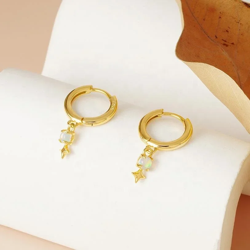 Close-up of Stardust Gold Opal Huggie Earrings highlighting the iridescent opal details, sparkling gold finish, and delicate hoop design.