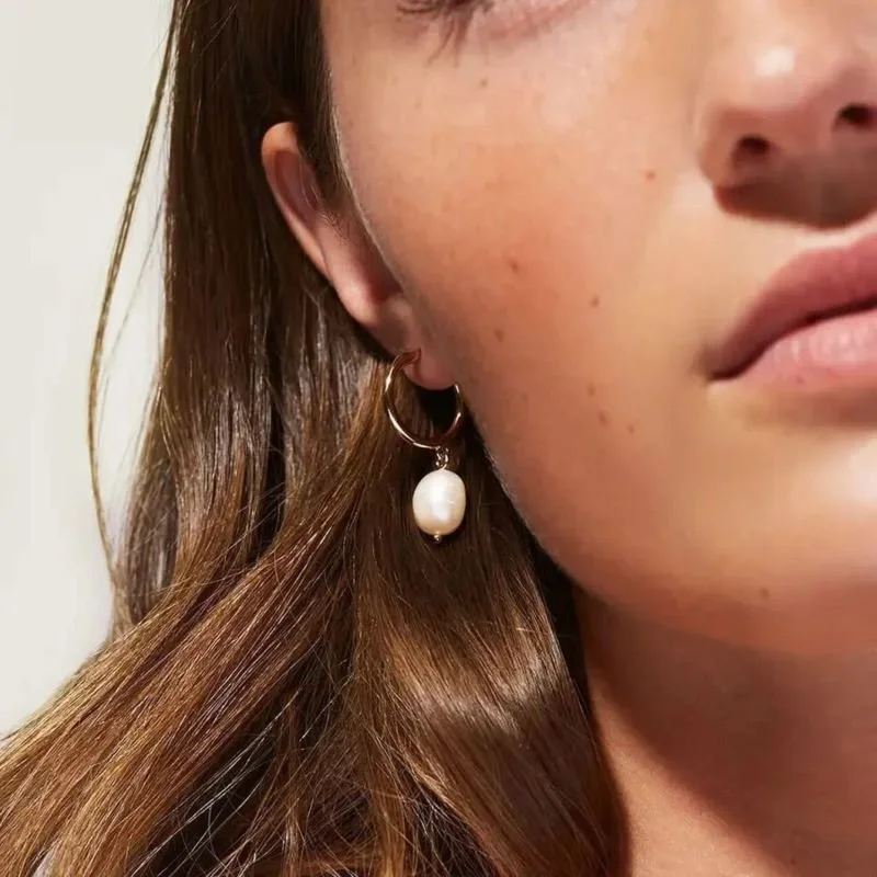 Aspen Gold Pearl Drop Hoop Earrings worn on model, showcasing a timeless pearl and gold jewelry style perfect for everyday wear or special occasions.