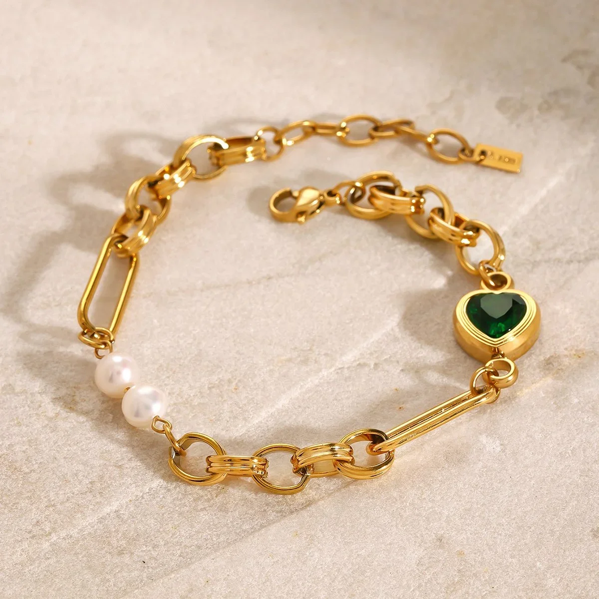 Emerald Heart Charm Bracelet with Pearls worn on wrist, showcasing a dainty gold jewelry style perfect for everyday wear
