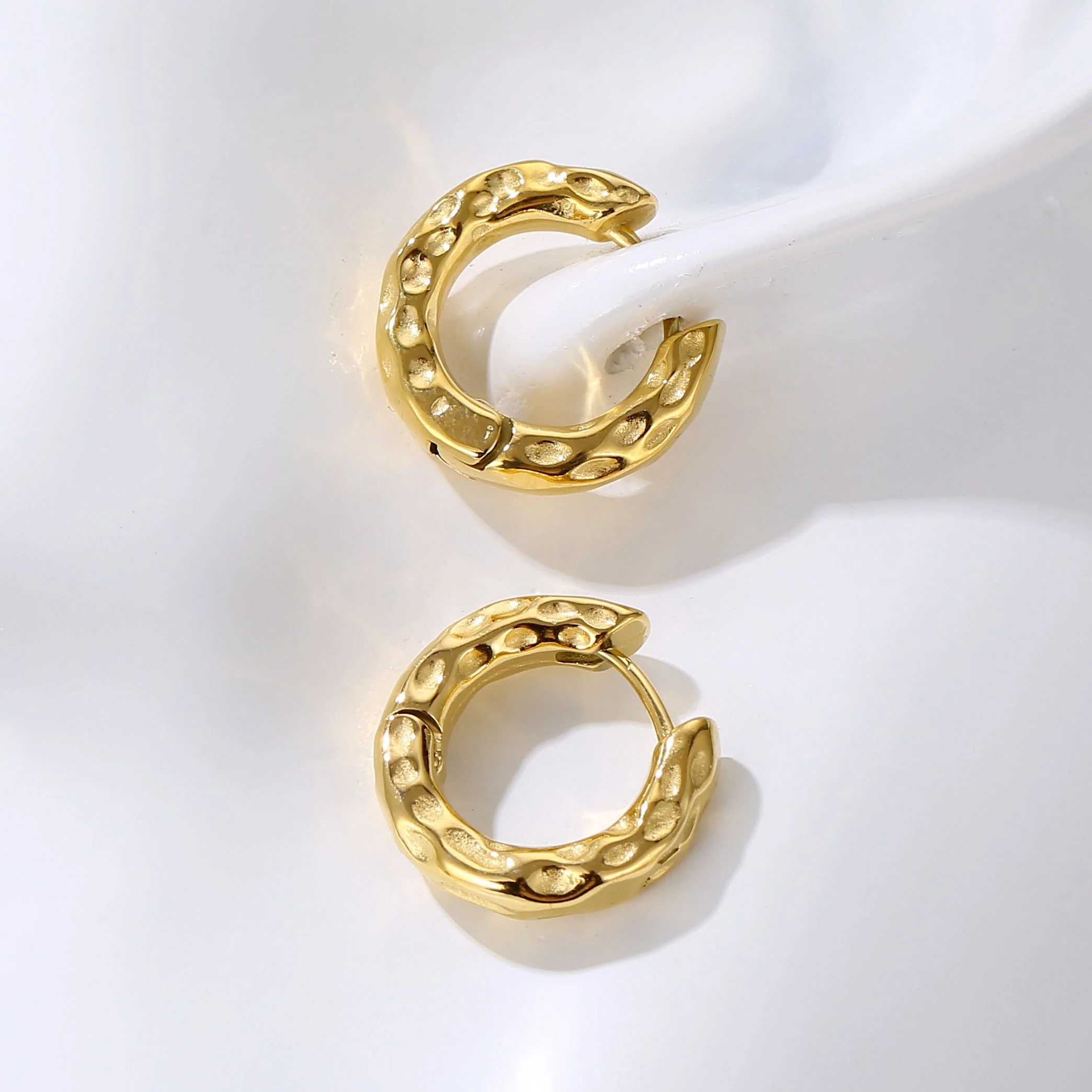 Small gold hammered hoop earrings that are lightweight, timeless, and high quality.