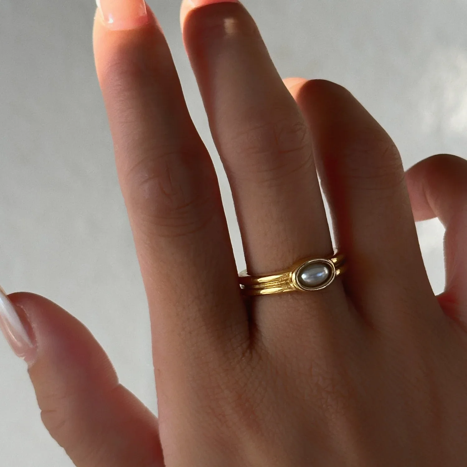 Alexandra Stackable Gold Freshwater Pearl Ring worn on finger, showcasing a timeless pearl jewelry look perfect for everyday wear and layering.