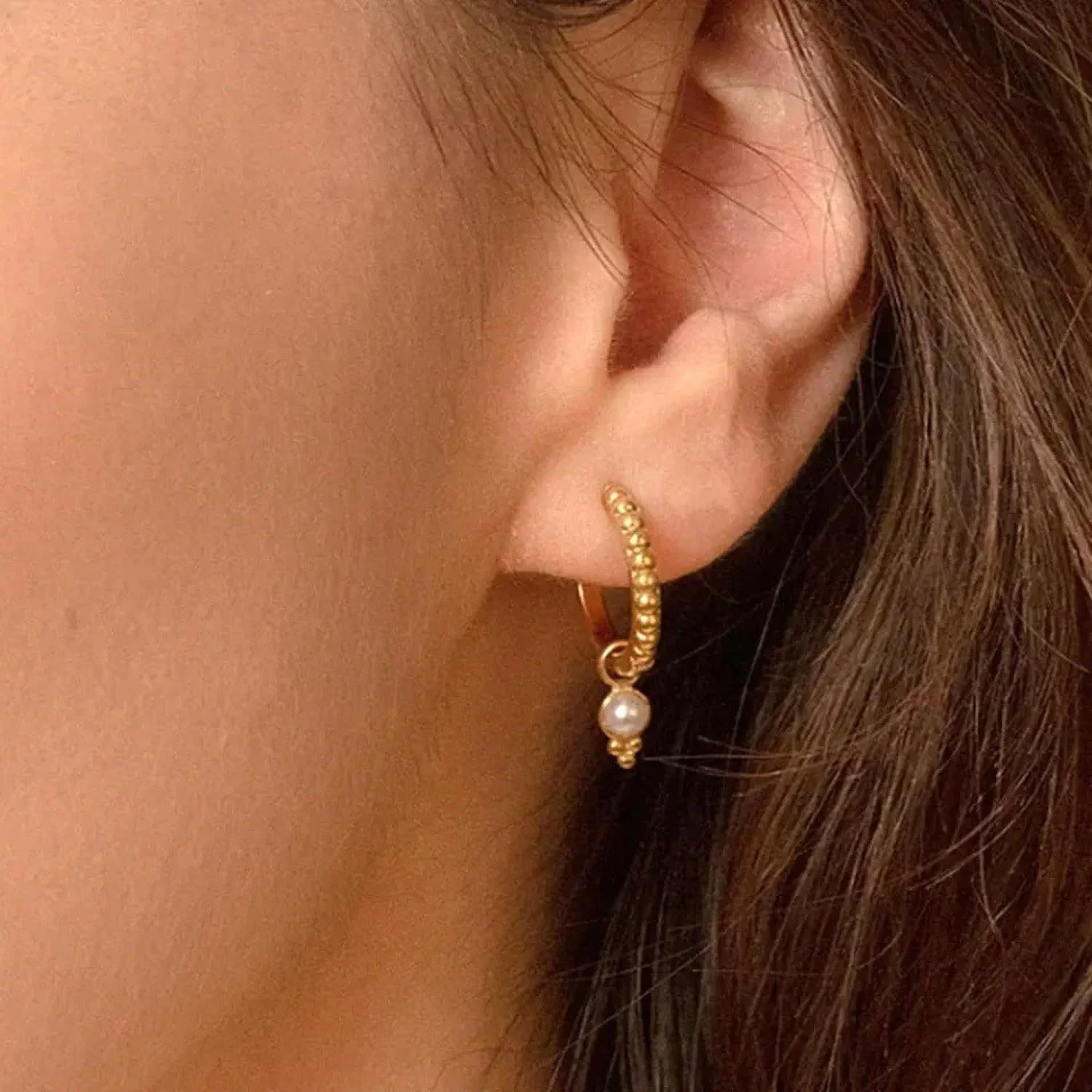 Close-up of Bali Beaded Freshwater Pearl Gold Huggie Earrings highlighting the textured gold bead details, natural pearl accents, and polished huggie hoop finish.