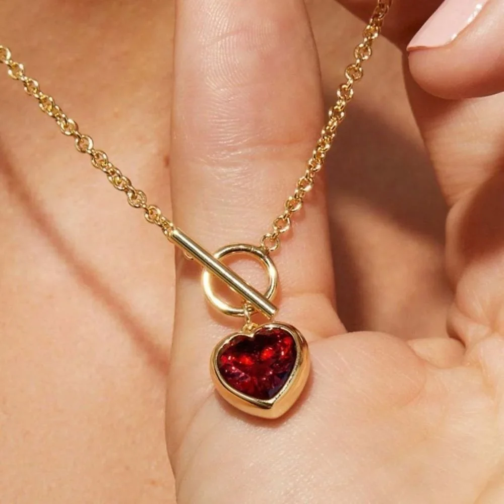 Close-up of Love Me Gold Red Heart Pendant Toggle Necklace highlighting the red heart charm, gold finish, and stylish toggle closure details.