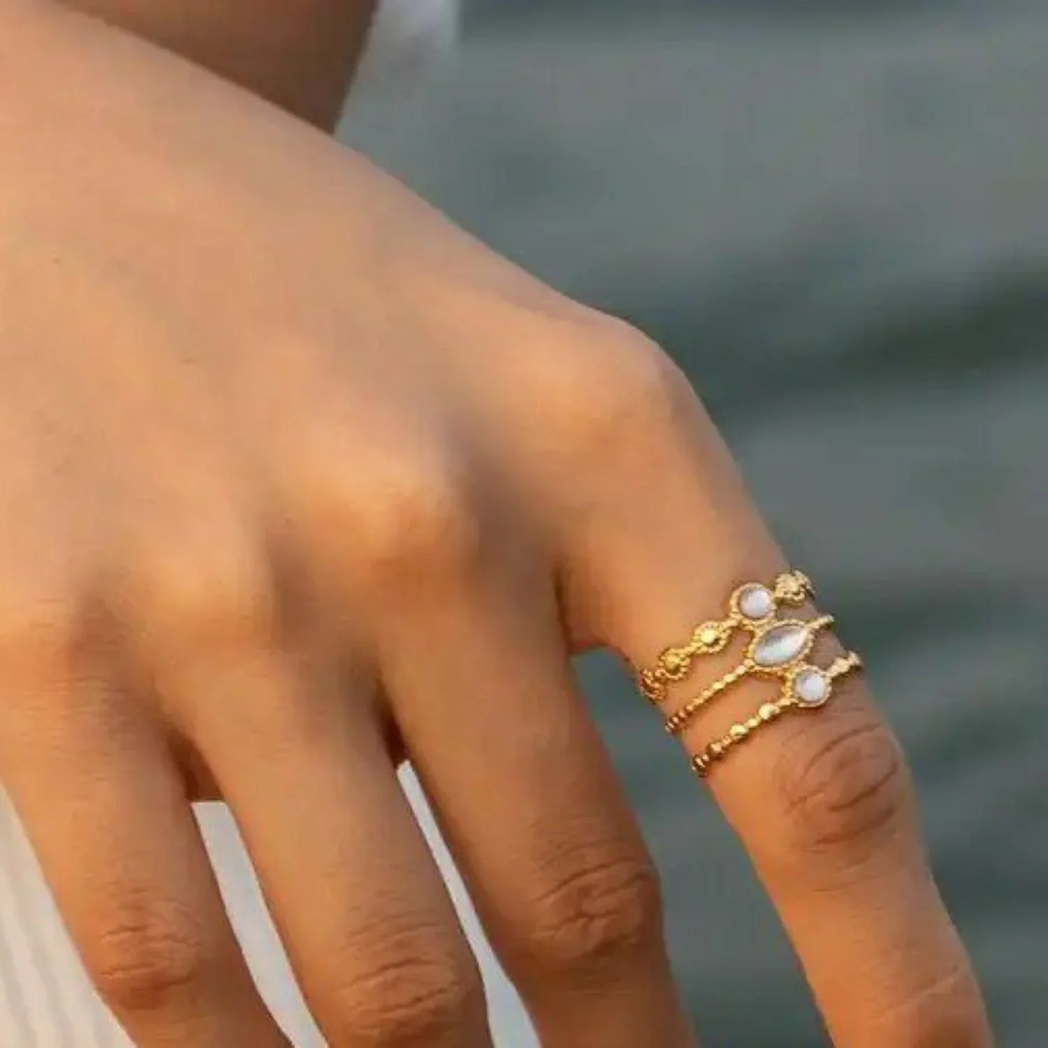 Floating On Clouds Adjustable Mother of Pearl Ring worn on finger, showcasing a dreamy and feminine gold jewelry style perfect for everyday wear.