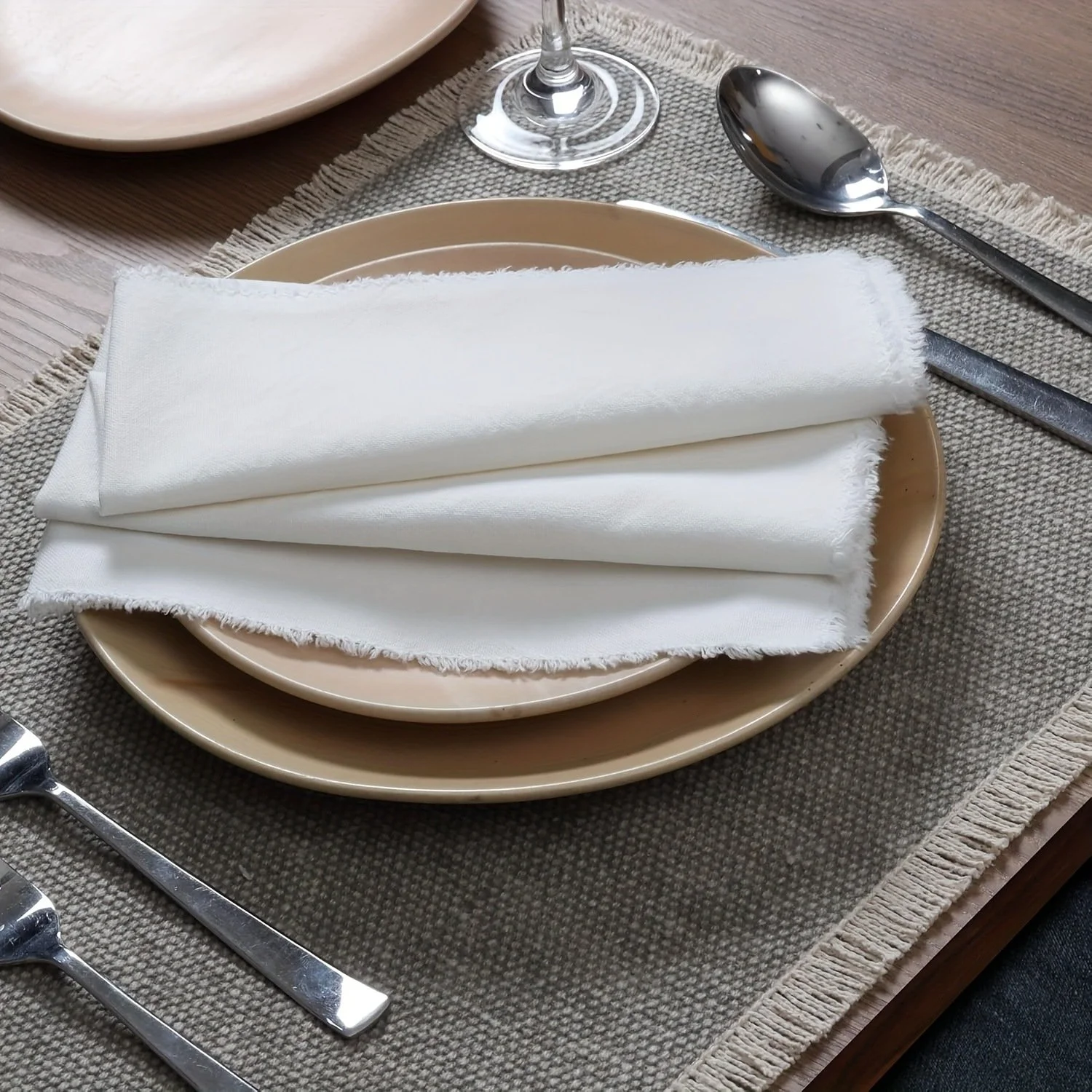 Set of four white 50% cotton 50% linen napkins with textured woven fabric and fringe trim, perfect for entertaining, seasonal, and modern dining décor.