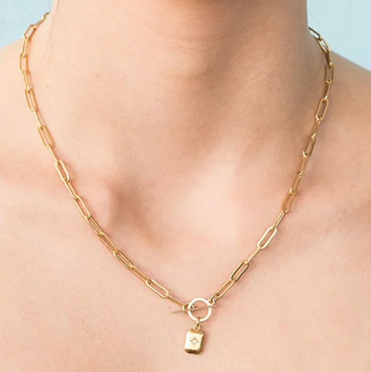 Gold Sunburst Toggle Chain Necklace worn on model, showcasing a celestial-inspired gold jewelry style perfect for everyday wear or special occasions.