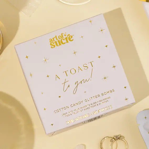 Whimsical cotton candy drink bombs fizzing in beverage creating shimmering glitter effect for party drinks.