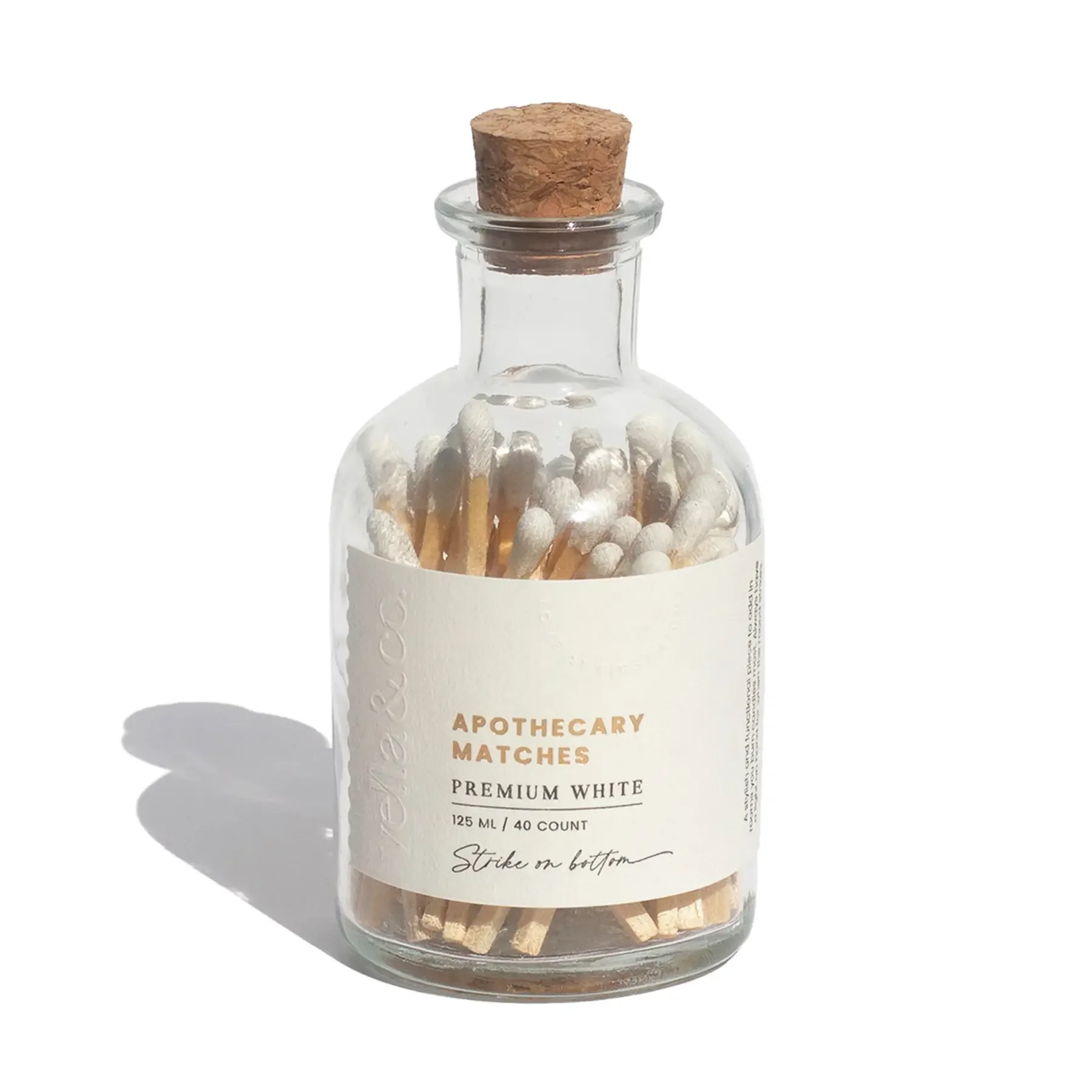 White-tipped apothecary matches stored in a clear glass container with a minimalist design..