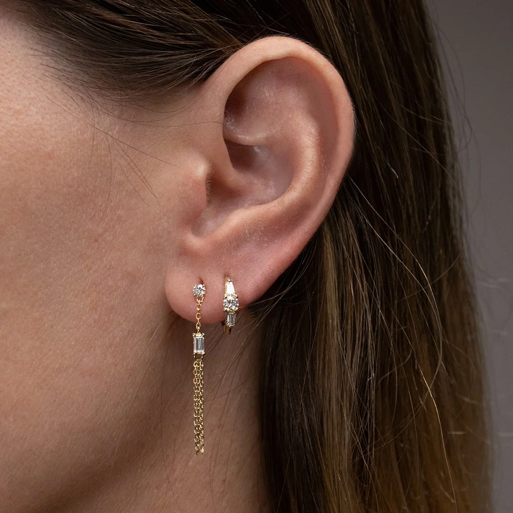 Woman wearing 18k gold plated cubic zirconia drop earrings.