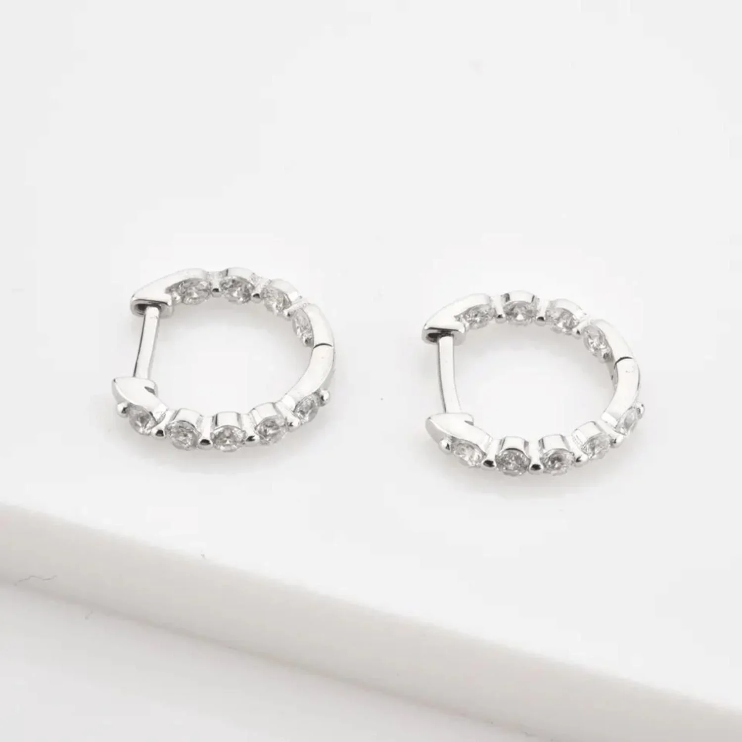 Silver Pavé Huggie Hoop Earrings featuring sparkling cubic zirconia stones set along a sleek silver hoop design for an elegant everyday look.