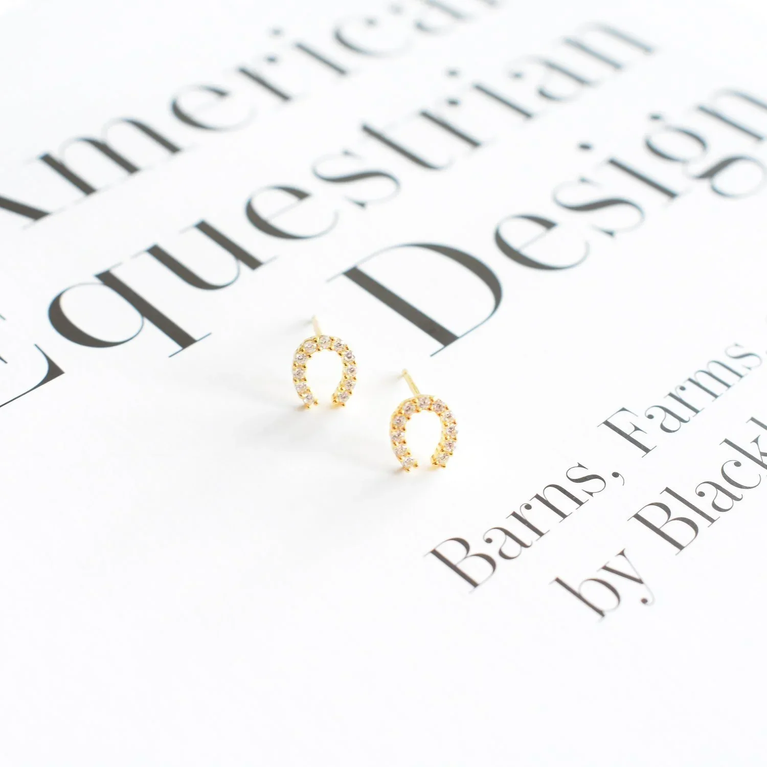 Close-up of Lexi CZ Horseshoe Stud Earrings highlighting the shimmering CZ details, lucky horseshoe shape, and elegant gold setting.