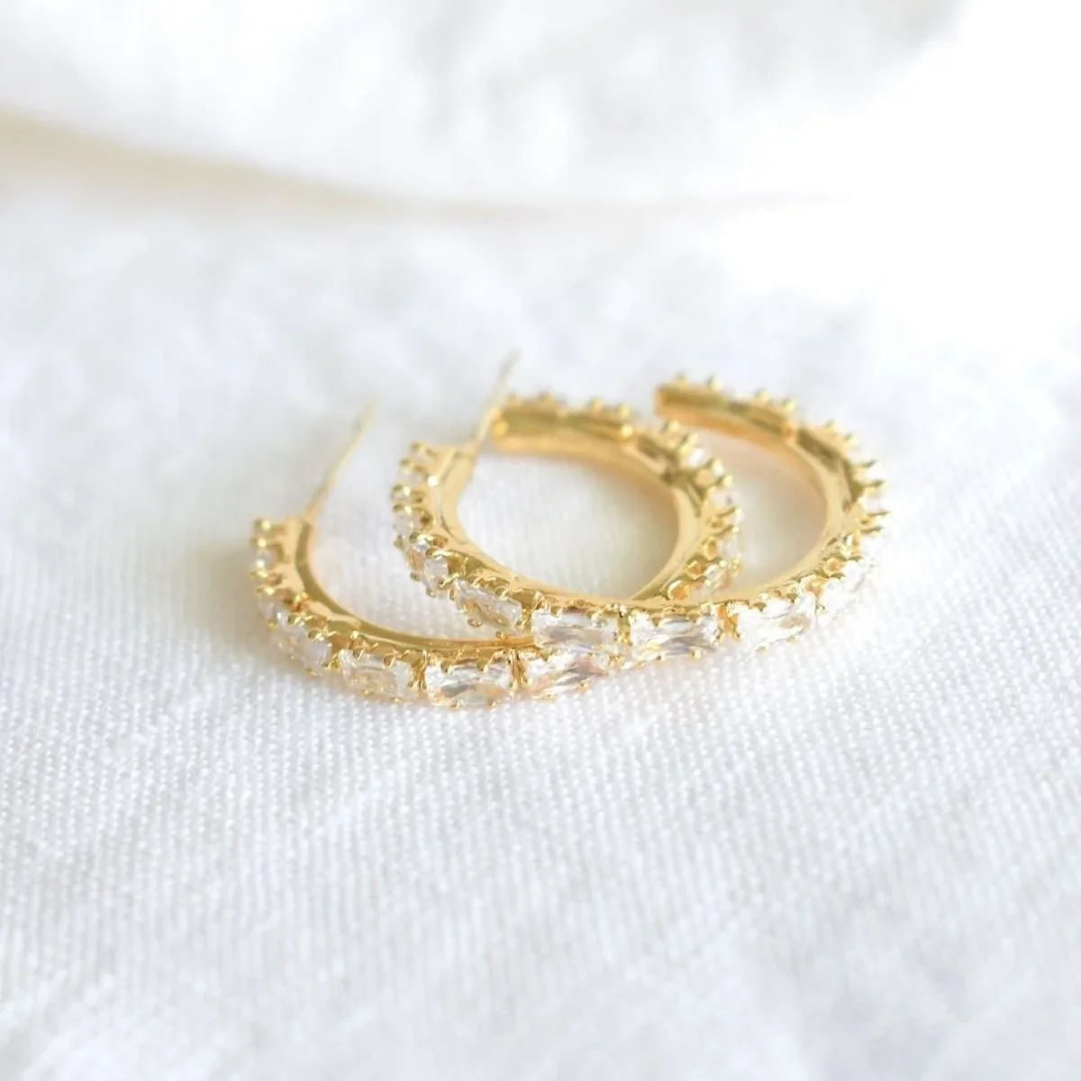 Close-up of Kristin Pavé Gold Hoop Earrings highlighting the shimmering CZ pavé details, sleek gold finish, and classic hoop silhouette.