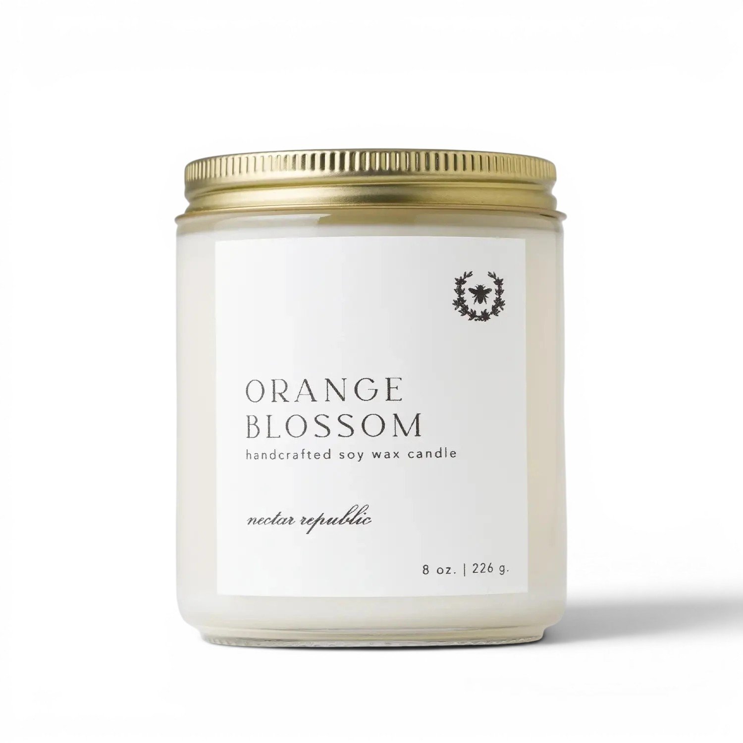 Orange Blossom scented soy candle in a frosted glass jar with a gold metal lid.