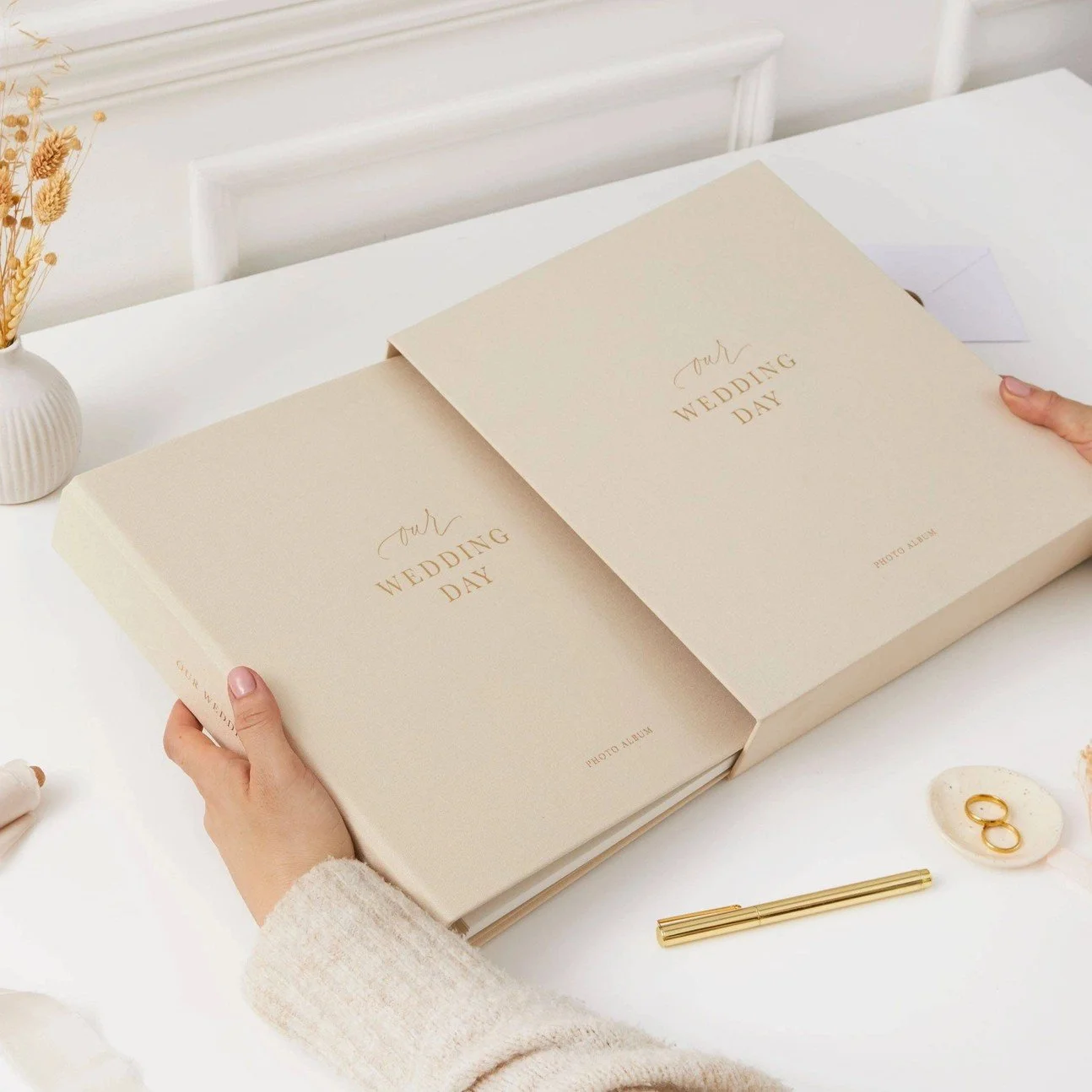 Elegant ivory linen wedding album displayed on table with thick lay flat pages and fine art wedding photographs.