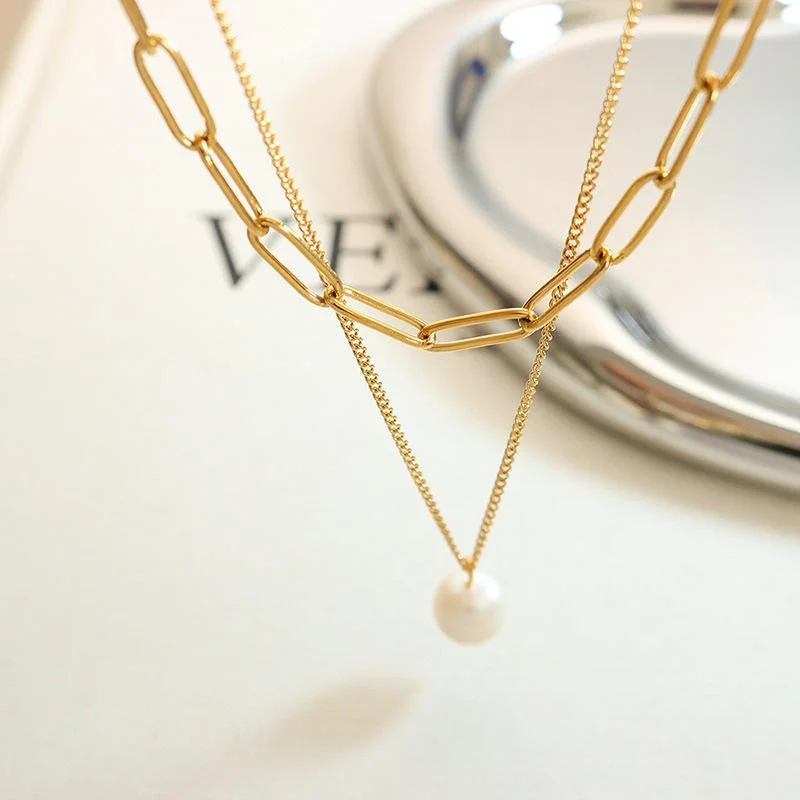 A gold layered necklace with a freshwater pearl and adjustable closure.