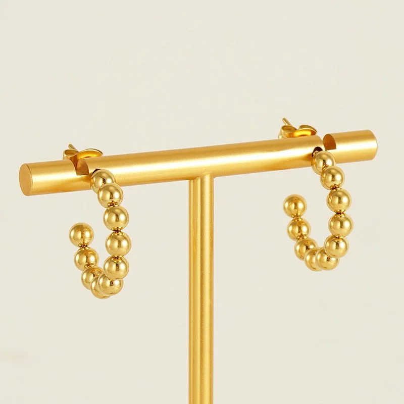 Small polished gold hoop earrings.