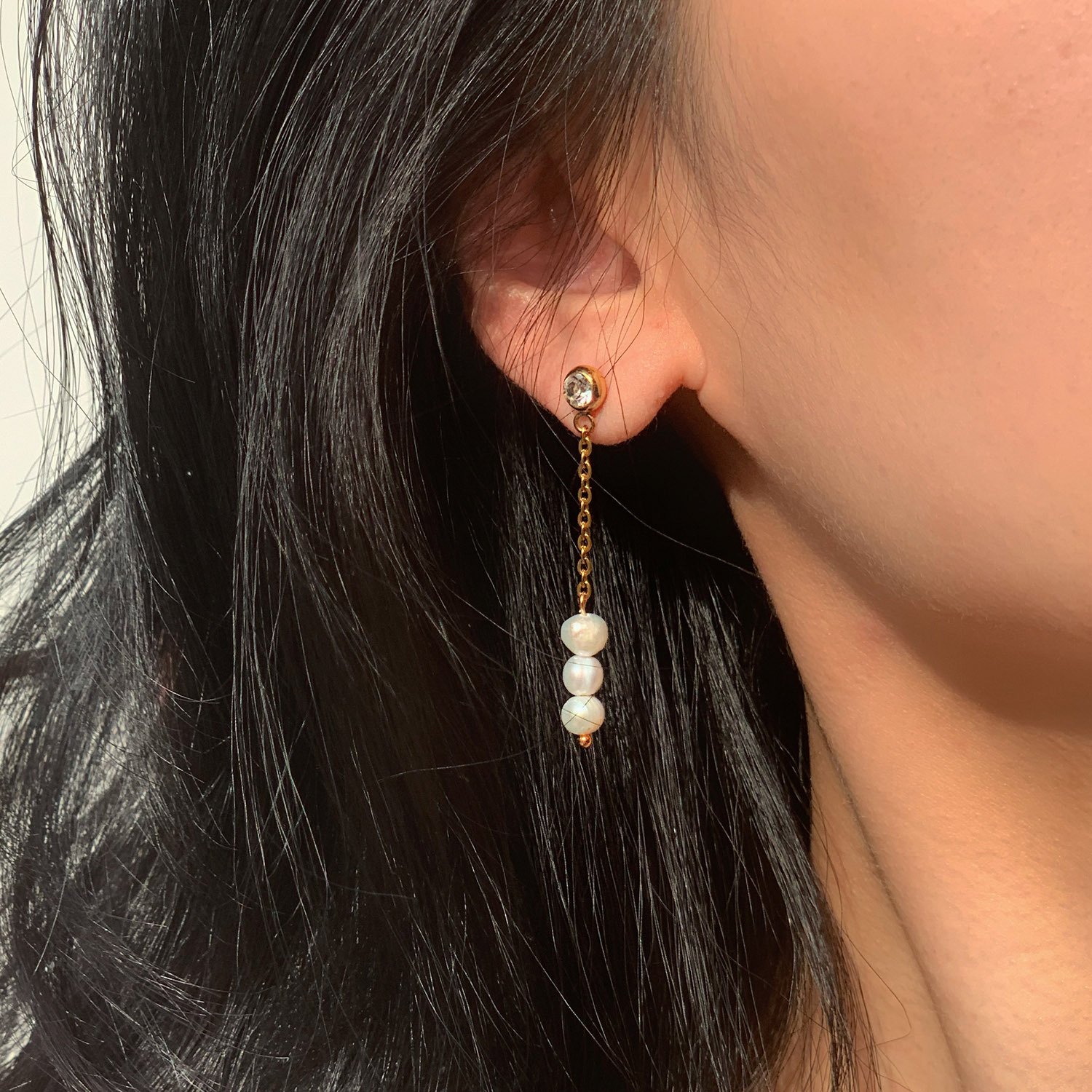 woman wearing gold pearl drop earrings ideal  for every occasion.