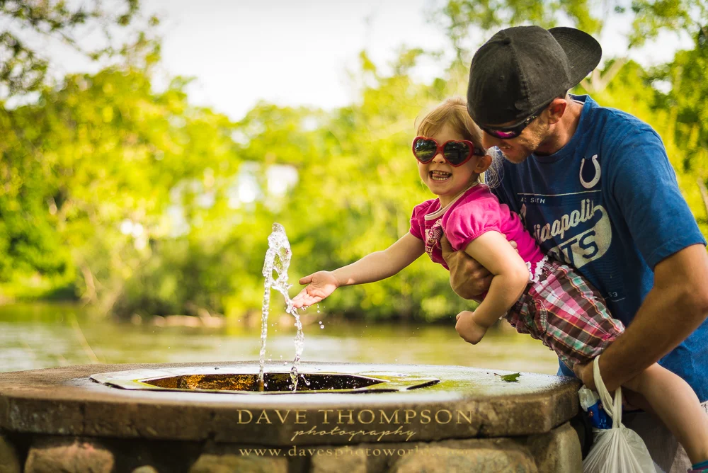 This little girl was really having fun drinking and playing in the water fountain!