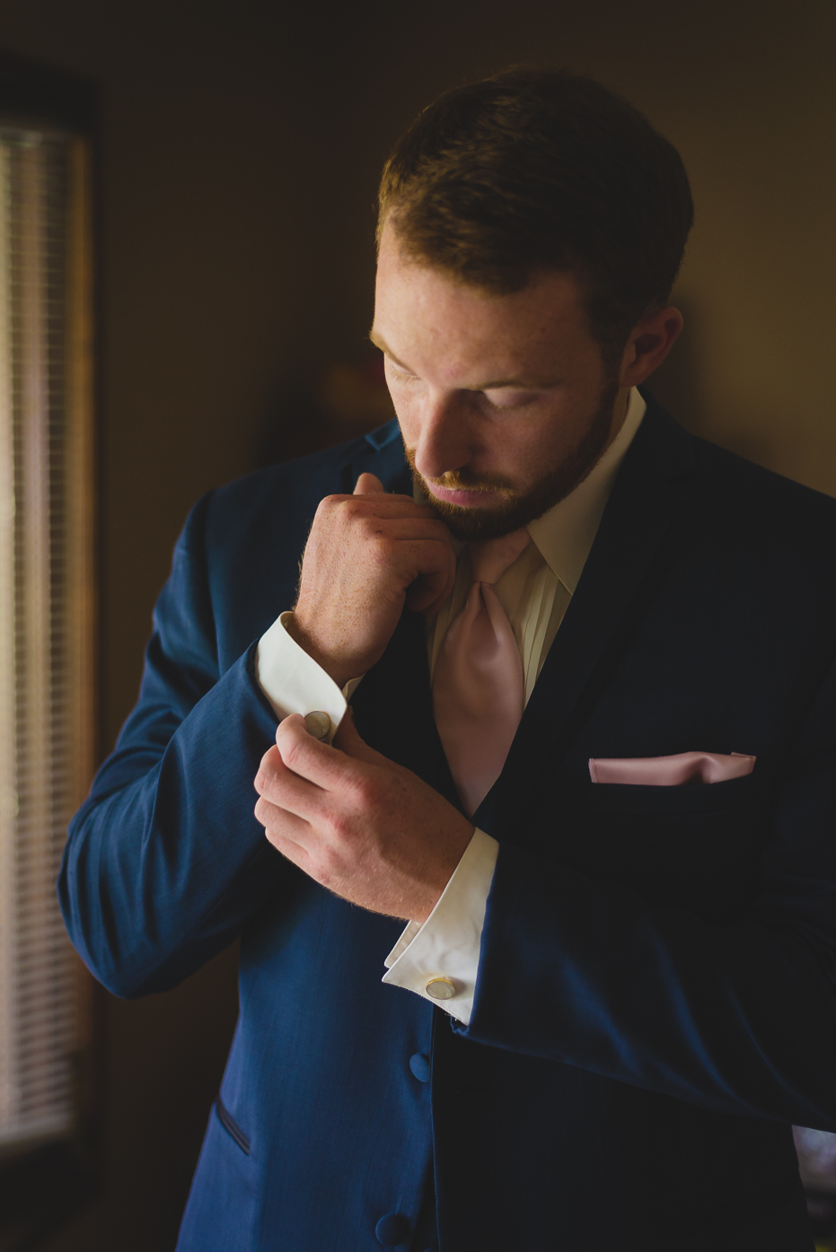 Groom adjusting cufflinks