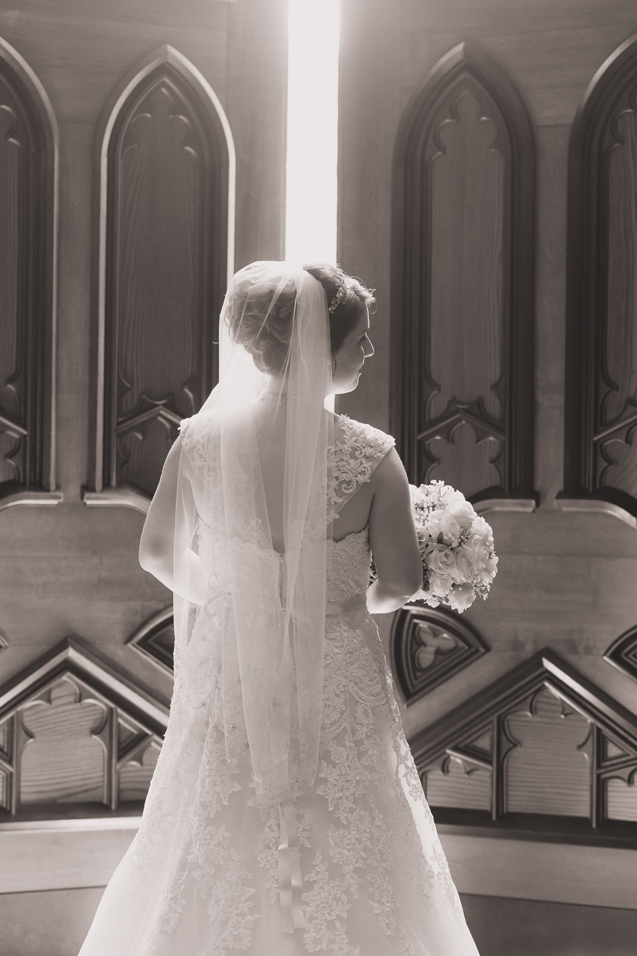 Bride with flowers in front of church doors