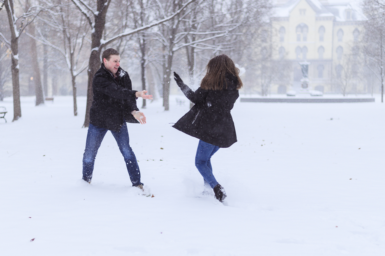  A cute couple in the middle of a snowball fight for the camera for enagement memories. 