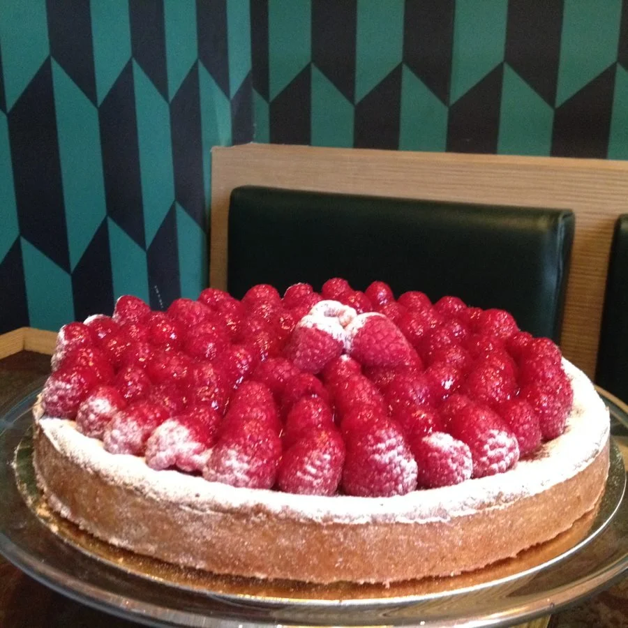 Tarte aux framboises sur un lit de pâte à la pistache pré-coupée en 12 parts