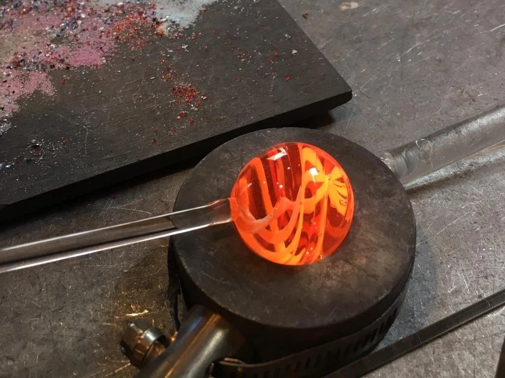 blown glass marble made during glassblowing class in flameworking studio made in pittsboro north carolina