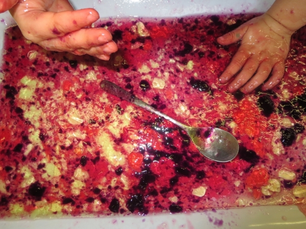 Du solid à liquide - les enfants se servent de leur sens de toucher, odorat, et vue pour explorer comment la texture du jello froid change quand il se réchauffe sous leurs mains.