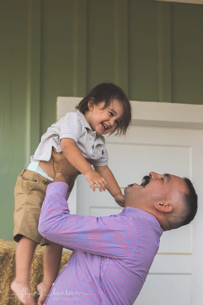 dad lifting son into air smiling