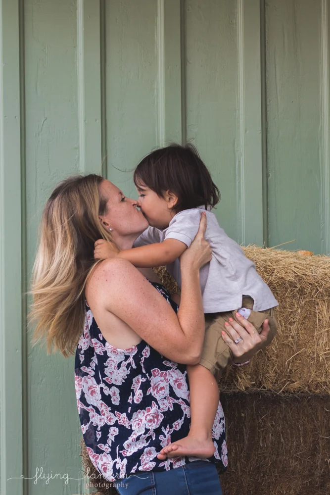 mom holding son and giving kiss