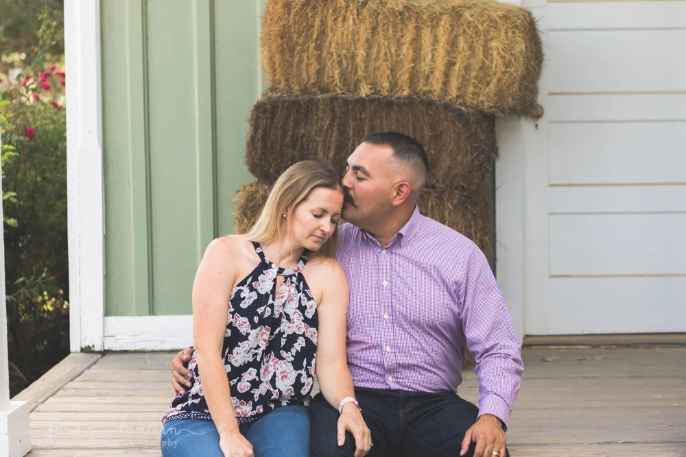 husband and wife embracing he kisses her on temple