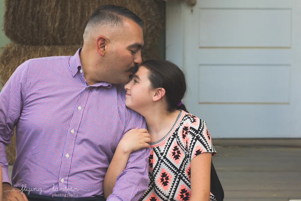 dad kisses daughter on forehead