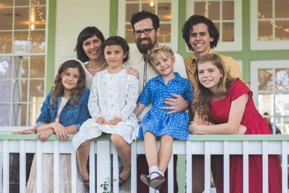 family of seven standing on porch looking at camera