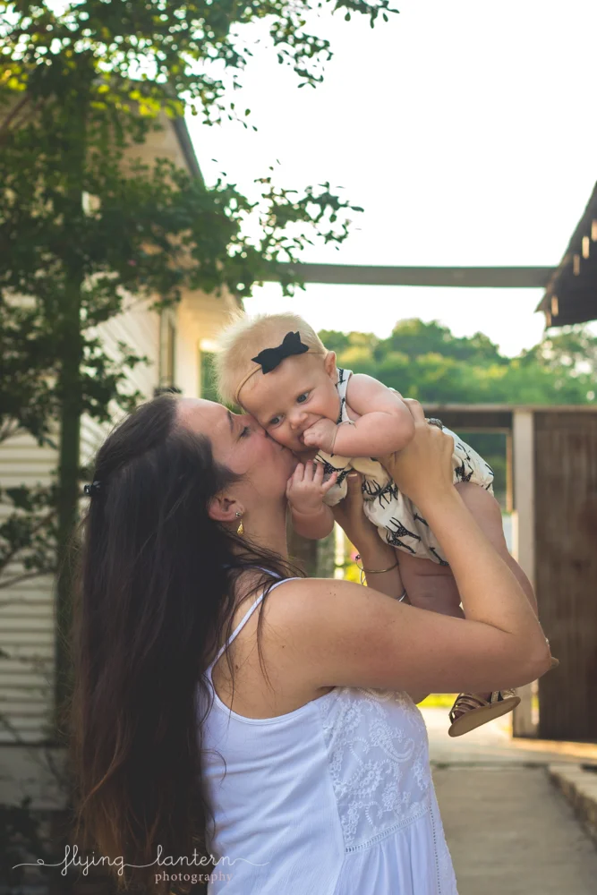 mother holding baby and kissing cheek
