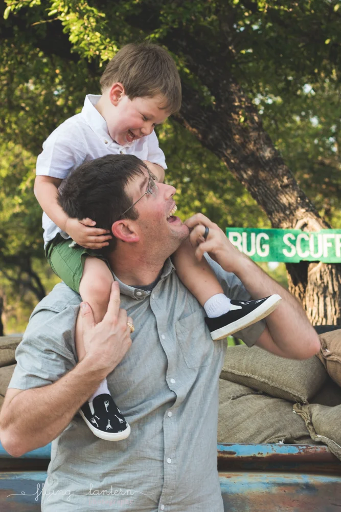 son on father's shoulder looking at each other