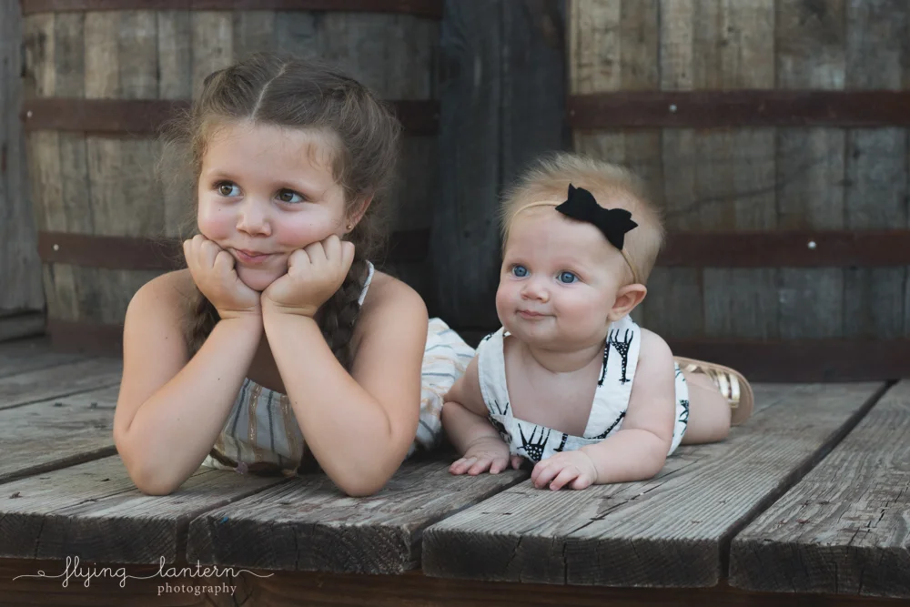 sisters laying on belly looking in same direction